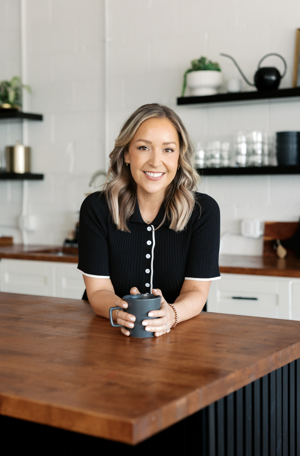 Jess Swaim smiling at the kitchen counter of the JLS studio, coffee in hand